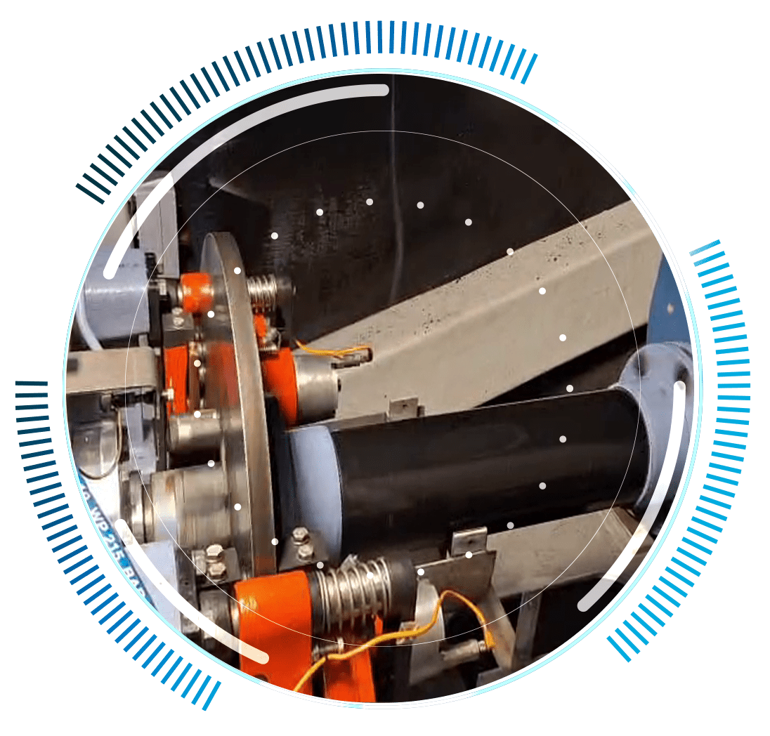 skywings.com.pl - A close-up of industrial machinery with orange and metallic components processing a black cylindrical object, overlaid with a circular digital graphic—perfectly illustrating wind turbine gearbox repair or advanced wind farm technical service. Wind Turbine Service & Maintenance, Windenergieanlagen-Service & Instandhaltung