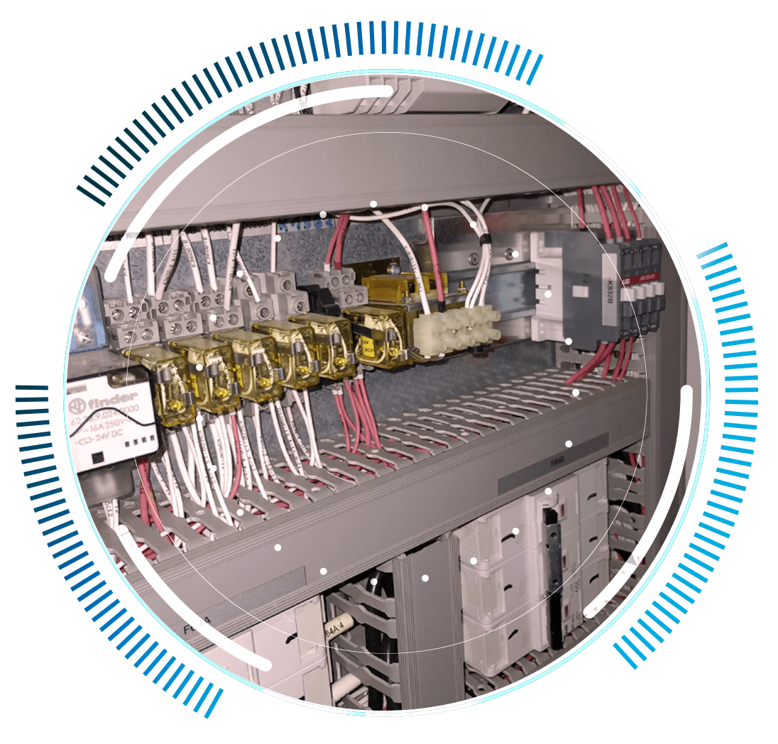 skywings.com.pl - Close-up of an electrical control panel with multiple wires, relays, and connectors, surrounded by a blue and white circular graphic overlay—ideal for wind turbine maintenance or elastomer bush replacement applications. Wind Turbine Service & Maintenance, Windenergieanlagen-Service & Instandhaltung