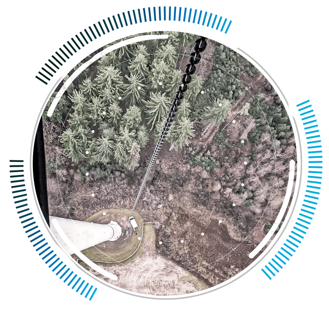 skywings.com.pl - Aerial view looking down from the top of a wind turbine during HSS bearing replacement, onto a forest and a small clearing, with blue and grey circular graphic elements framing the image. Wind Turbine Service & Maintenance, Windenergieanlagen-Service & Instandhaltung
