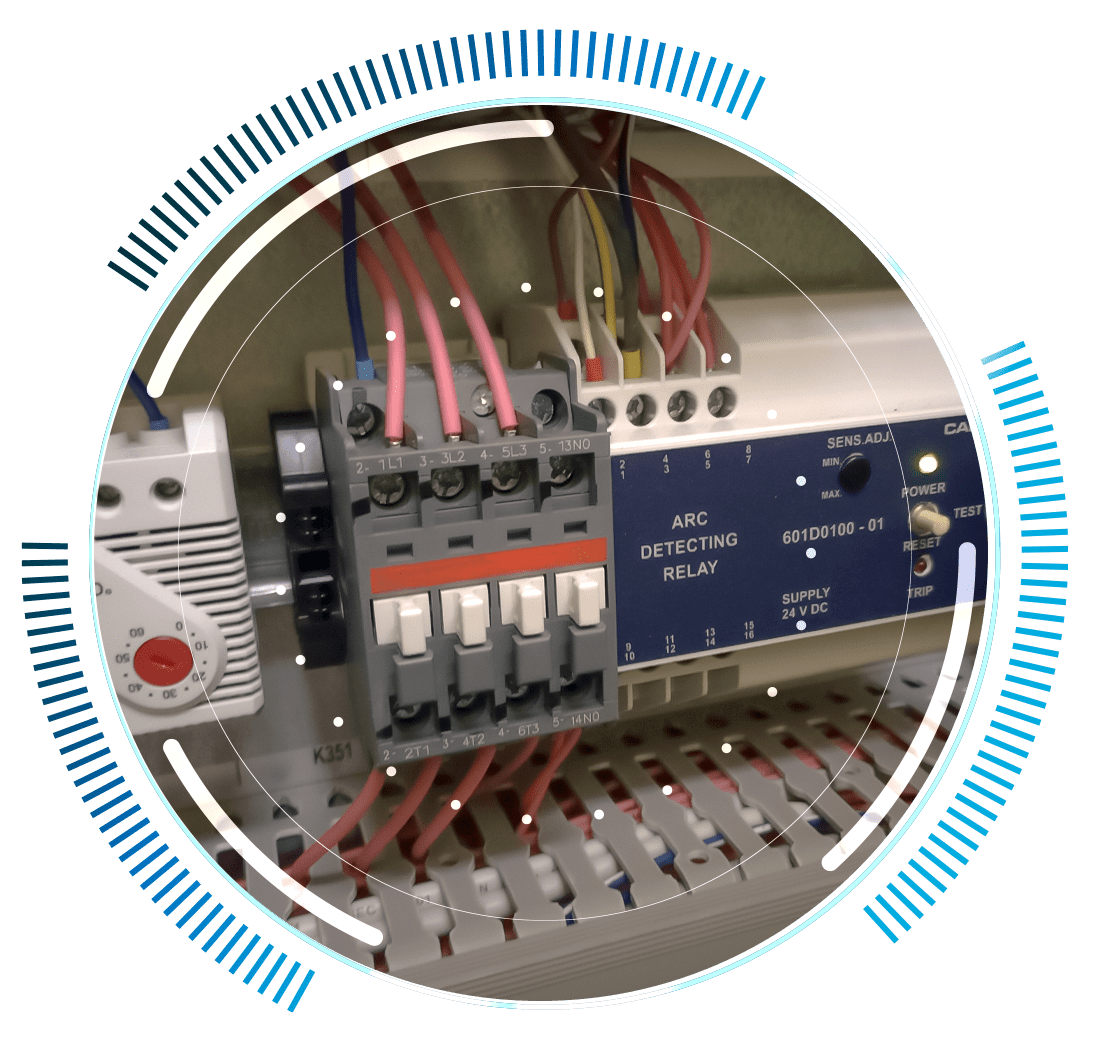 skywings.com.pl - Close-up of an electrical control panel with ARC detecting relay, coloured wires, switches, and electronic components—highlighting Vestas-Getriebe-Service for advanced Windturbinen-Service—overlaid with a circular digital graphic design. Wind Turbine Service & Maintenance, Windenergieanlagen-Service & Instandhaltung