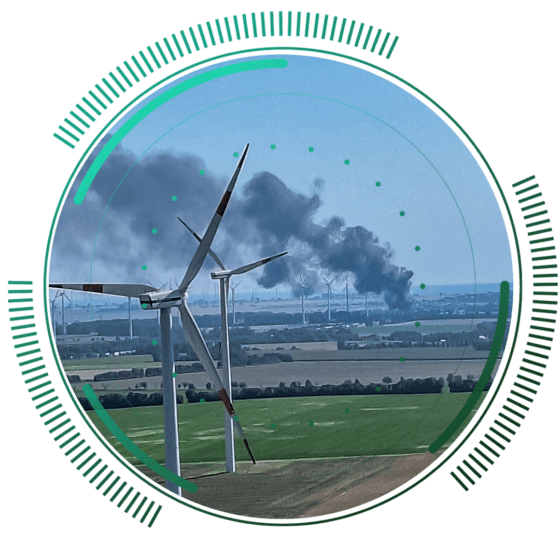 skywings.com.pl - A field with wind turbines in the foreground; in the distance, thick black smoke rises into the sky, partially obscuring more wind turbines—an urgent reminder of the importance of reliable Vestas gearbox servicing. Circular graphic elements overlay the image. Wind Turbine Service & Maintenance, Windenergieanlagen-Service & Instandhaltung