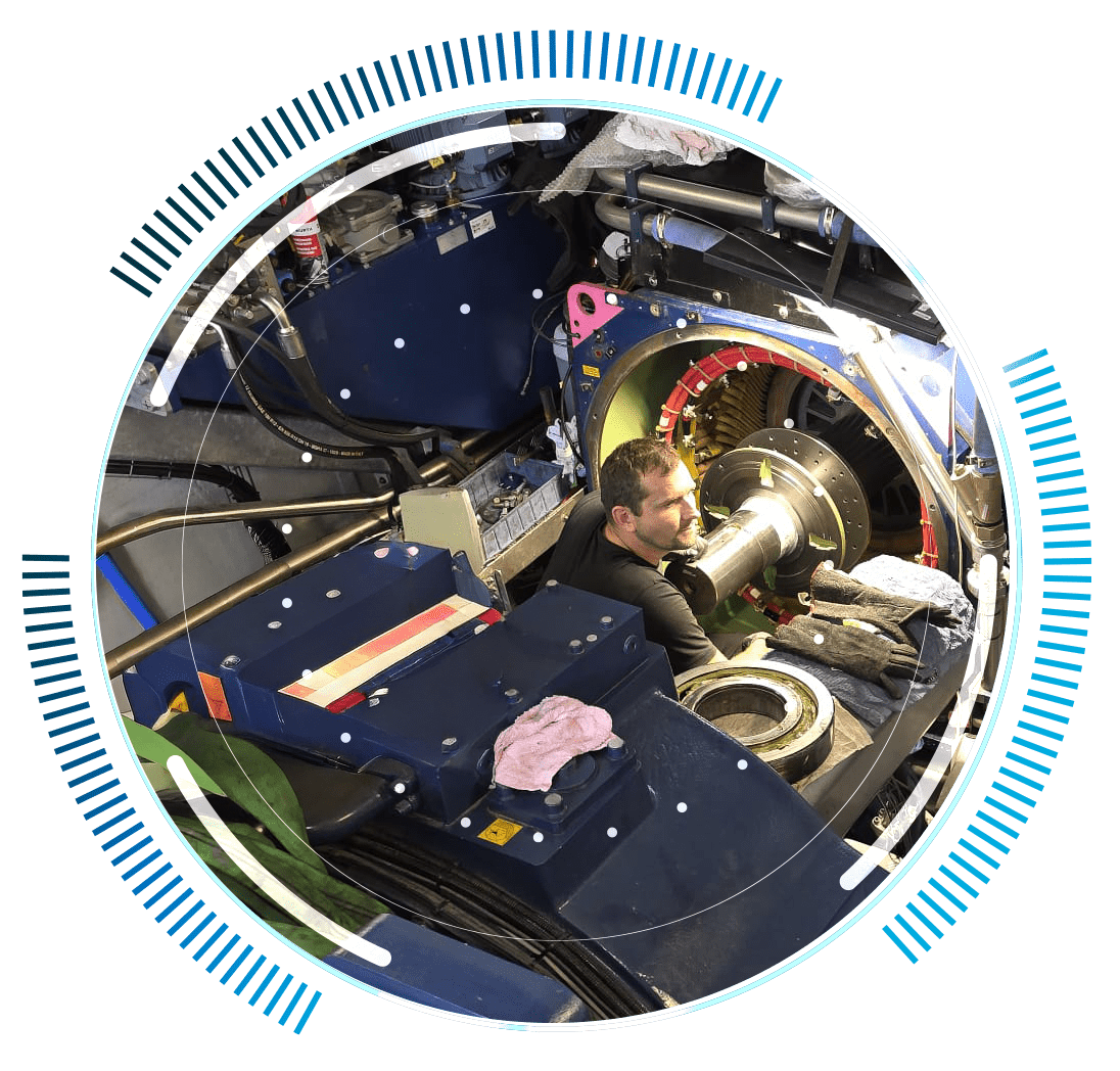skywings.com.pl - A man is working inside a large, complex machine, surrounded by metal parts and tools—its circular blue graphics hint at advanced technology and engineering analysis, ideal for Vestas gearbox service or gearbox bush replacement. Wind Turbine Service & Maintenance, Windenergieanlagen-Service & Instandhaltung
