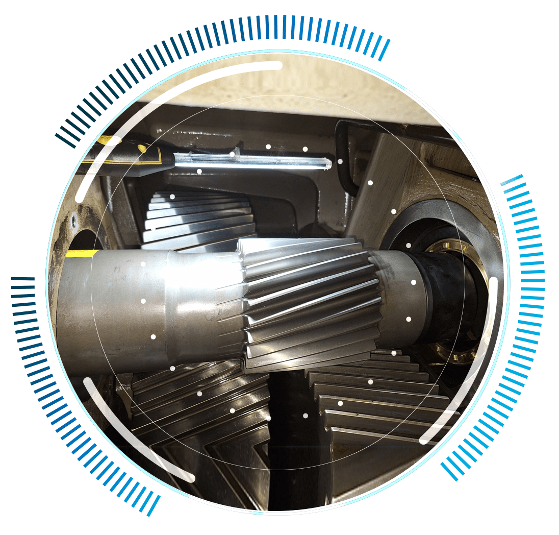 skywings.com.pl - Close-up photo of metal gears inside a machine, partially overlaid with a circular blue and white digital graphic resembling data or a user interface, illustrating advanced wind turbine hydraulic system service technology. Wind Turbine Service & Maintenance, Windenergieanlagen-Service & Instandhaltung