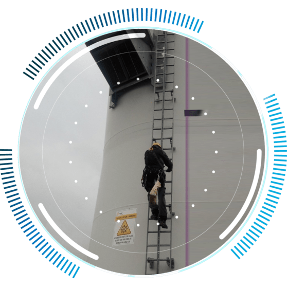 skywings.com.pl - A worker in safety gear climbs a vertical ladder attached to a tall industrial structure, possibly during wind turbine electrical maintenance, with warning signs visible on the surface. A circular digital graphic overlays the image. Wind Turbine Service & Maintenance, Windenergieanlagen-Service & Instandhaltung