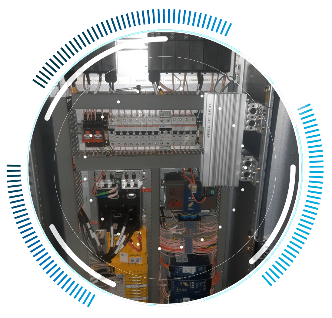 skywings.com.pl - A close-up view of an electrical control panel with various wires, circuit breakers, and electronic components, framed by a circular graphic with blue accents—ideal for illustrating wind turbine drivetrain maintenance procedures. Wind Turbine Service & Maintenance, Windenergieanlagen-Service & Instandhaltung